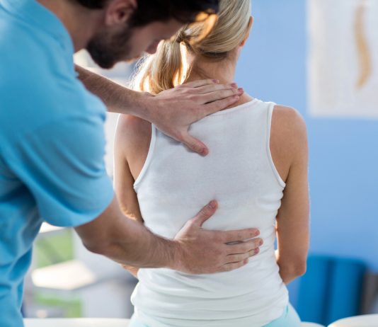 Het belang van fysiotherapie voor de mentale gezondheid Mannelijke fysiotherapeut masseert rug van vrouw