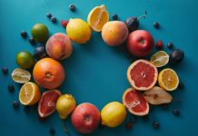 Jouw gezonde lifestyle begint met deze 6 vitamines Cirkel van fruit op blauwe achtergrond