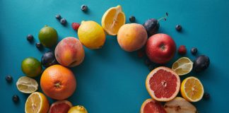 Jouw gezonde lifestyle begint met deze 6 vitamines Cirkel van fruit op blauwe achtergrond