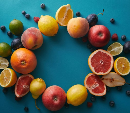 Jouw gezonde lifestyle begint met deze 6 vitamines Cirkel van fruit op blauwe achtergrond