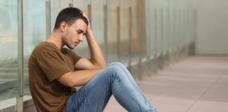 Deze maatregelen zorgen voor minder depressies onder jongeren Tienerjongen kijkt bezorgd en zit op de grond